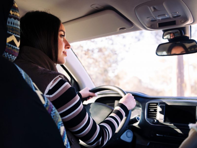 young caucasian woman driving her camper van to new horizons, concept of road trip and nomad lifestyle, copy space for text